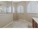 Main bathroom featuring a glass shower, three arched windows, and decorative tiles at 10927 Se 168Th Loop, Summerfield, FL 34491