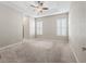 Spacious main bedroom with carpet, plantation shutters, and a tray ceiling with fan at 10927 Se 168Th Loop, Summerfield, FL 34491