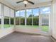 Screened lanai featuring windows and a door offering views of the landscaped backyard at 10927 Se 168Th Loop, Summerfield, FL 34491