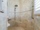 Detailed view of the shower with tan tile, a built-in seat, and a hand-held shower head at 10927 Se 168Th Loop, Summerfield, FL 34491