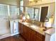 Bathroom featuring double sinks, a shower with glass door, framed mirrors, and unique decorative monkey lamps at 12183 Se 178Th St, Summerfield, FL 34491