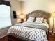 Bedroom featuring a large bed with patterned bedding and a decorative headboard at 12183 Se 178Th St, Summerfield, FL 34491
