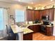 Cozy kitchen with wood cabinets, granite countertops, and bar seating area at 12183 Se 178Th St, Summerfield, FL 34491