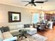 Cozy living space with a sectional sofa, ceiling fan, and view into the dining area and kitchen at 12183 Se 178Th St, Summerfield, FL 34491