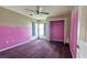 Bedroom with purple carpet, closet, and peeling pink and neutral colored walls at 12512 Draw Dr Dr, Grand Island, FL 32735