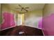 Bedroom with pink and neutral colored walls, closet, purple carpet and ceiling fan at 12512 Draw Dr Dr, Grand Island, FL 32735