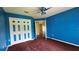 Bedroom with a large closet, carpet, ceiling fan, and bright blue walls at 12512 Draw Dr Dr, Grand Island, FL 32735