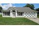 Well-maintained single-story home featuring a classic white facade and large garage, on a sunny day at 12512 Draw Dr Dr, Grand Island, FL 32735