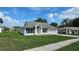 Attractive single-story home with an attached two car garage and manicured lawn on a sunny day at 12512 Draw Dr Dr, Grand Island, FL 32735