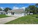 Well-maintained single-story home featuring a classic white facade and large garage, on a sunny day at 12512 Draw Dr Dr, Grand Island, FL 32735