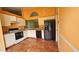 Functional kitchen featuring white cabinetry, black appliances, and tile flooring at 12512 Draw Dr Dr, Grand Island, FL 32735