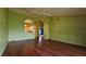 Open-concept living room with hardwood floors, archway to kitchen, and bright lighting at 12512 Draw Dr Dr, Grand Island, FL 32735