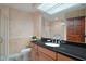 Bathroom features a spacious vanity with dark countertops and a large mirror with decorative ceiling trim at 13033 Se 158Th Ln, Weirsdale, FL 32195