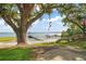 Scenic beach view featuring mature trees, lush greenery, and tranquil lake with docks at 13033 Se 158Th Ln, Weirsdale, FL 32195