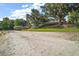 Sandy beach leading to lake with docks, lush green lawn, and mature trees creating a serene setting at 13033 Se 158Th Ln, Weirsdale, FL 32195