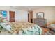 Well-lit bedroom features a palm-leaf patterned bedspread and decor, and a light wood dresser with a mirror at 13033 Se 158Th Ln, Weirsdale, FL 32195