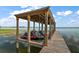 Exterior image of a covered boat dock with jet skis parked, offering convenience for water activities at 13033 Se 158Th Ln, Weirsdale, FL 32195