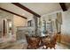 Cozy dining area with a glass table, brick accents, beam ceilings, and neutral-toned walls at 13033 Se 158Th Ln, Weirsdale, FL 32195