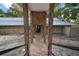 Exterior shot from the stairs looking toward the door with stone columns and accents on the house at 13033 Se 158Th Ln, Weirsdale, FL 32195