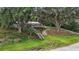 Exterior view of a house with a deck, stairs, and large trees at 13033 Se 158Th Ln, Weirsdale, FL 32195