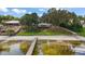 Picturesque lakefront estate with a sandy beach, sprawling lawn, and lush trees, offering a serene retreat at 13033 Se 158Th Ln, Weirsdale, FL 32195