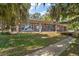 Attractive brick home with a covered patio and lush, mature trees at 13033 Se 158Th Ln, Weirsdale, FL 32195