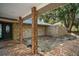 Front porch with a stone paver floor and brick columns leading to a glass front door at 13033 Se 158Th Ln, Weirsdale, FL 32195