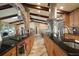Open kitchen with black countertops, wood cabinets, stainless steel appliances, and decorative brick features at 13033 Se 158Th Ln, Weirsdale, FL 32195