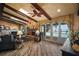 Spacious living room boasting a brick fireplace, beamed ceilings, and large windows offering a lake view at 13033 Se 158Th Ln, Weirsdale, FL 32195