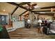 Elegant living room with wood floors, exposed beams, and a brick accent wall at 13033 Se 158Th Ln, Weirsdale, FL 32195