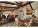 Inviting living room featuring brick accents, wooden beams, and comfortable seating next to a quaint dining area at 13033 Se 158Th Ln, Weirsdale, FL 32195