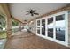 Spacious brick patio featuring ceiling fans, brick columns, black railing, and picturesque lake views at 13033 Se 158Th Ln, Weirsdale, FL 32195