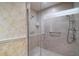 Modern shower with marble walls, grab bars, and glass enclosure for a spa-like experience at 13033 Se 158Th Ln, Weirsdale, FL 32195