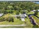 Aerial shot displays a well-maintained home with RV parking, a pond with dock, and ample yard space surrounded by trees at 135 N James Pl, Groveland, FL 34736