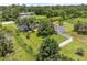 Aerial view of a home on a large lot with a pond, fenced yard, a pool, and mature trees, ensuring privacy at 135 N James Pl, Groveland, FL 34736