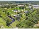 Aerial view showing the property's pond, a single-story home, plus other buildings, and ample green space at 135 N James Pl, Groveland, FL 34736