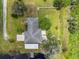 Aerial shot of the property showcasing its layout, including the backyard with a fire pit, a pool, and access to a pond at 135 N James Pl, Groveland, FL 34736
