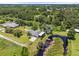 Expansive aerial view of the property showcasing a large backyard, pond, and surrounding lush greenery at 135 N James Pl, Groveland, FL 34736
