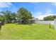 A lush backyard features a large tree, a manicured lawn, and a fire pit at 135 N James Pl, Groveland, FL 34736