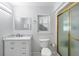 Bright bathroom with white vanity, marble countertop, and glass-enclosed shower at 135 N James Pl, Groveland, FL 34736