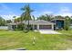 Charming single-story home with a two-car garage and a covered RV parking space, situated on a well-manicured lawn at 135 N James Pl, Groveland, FL 34736