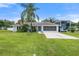 Charming single-story home with well-maintained lawn, mature landscaping, and spacious driveway at 135 N James Pl, Groveland, FL 34736