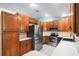 Traditional kitchen features wood cabinets, stainless steel appliances, and white countertops at 135 N James Pl, Groveland, FL 34736