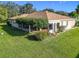 Spacious backyard featuring a covered patio, lush green lawn, and mature landscaping at 13700 Se 90Th Ct, Summerfield, FL 34491
