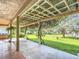 Tranquil backyard view from covered patio showing meticulously maintained lawn and mature trees, great for outdoor enjoyment at 13700 Se 90Th Ct, Summerfield, FL 34491