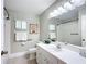Tidy bathroom with white cabinets, a framed mirror and shower with curtain at 13700 Se 90Th Ct, Summerfield, FL 34491