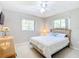 Cozy bedroom featuring neutral walls, a ceiling fan, and light-filled windows at 13700 Se 90Th Ct, Summerfield, FL 34491
