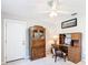 Neat bedroom offering a ceiling fan, desk, and wood secretary at 13700 Se 90Th Ct, Summerfield, FL 34491