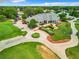 Elegant clubhouse featuring beautiful landscaping, circular driveway, and golf cart parking for community gatherings at 13700 Se 90Th Ct, Summerfield, FL 34491