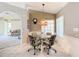 Cozy dining area with glass table, patterned chairs, chandelier, and arched doorway to the living room at 13700 Se 90Th Ct, Summerfield, FL 34491